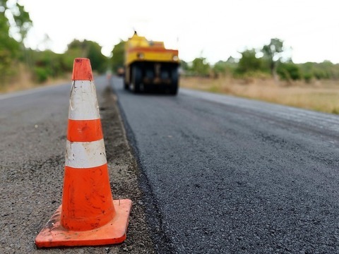 Cone next to road being paved