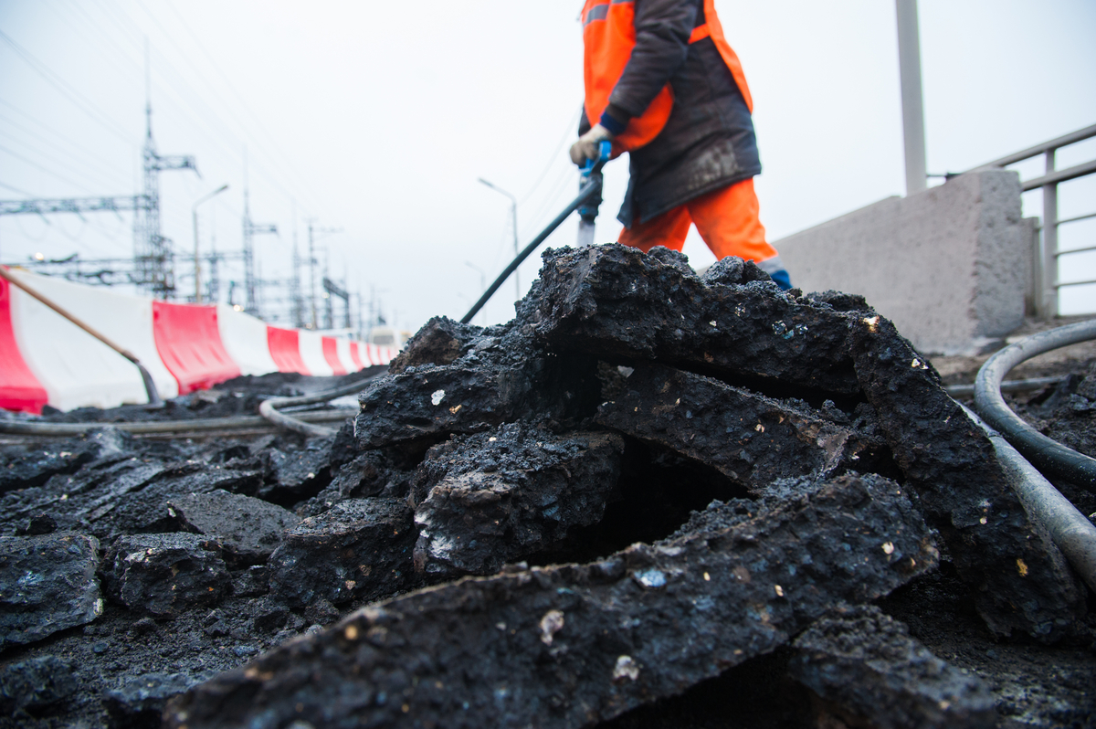 road worker removing old asphalt with a jackhammer